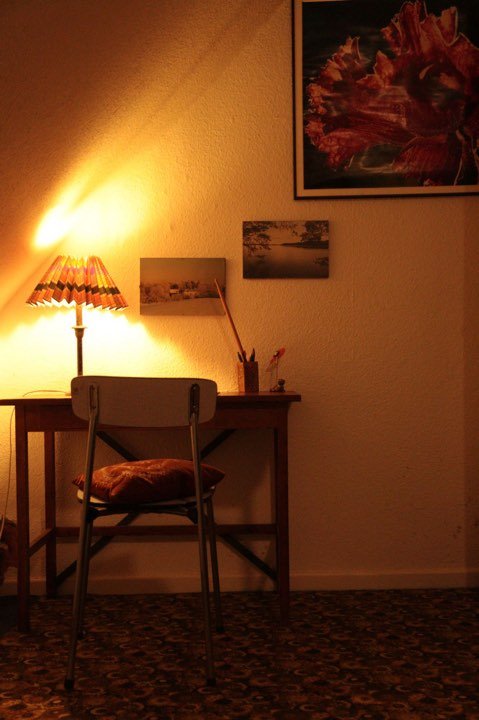 Schreibtisch mit Lampe und Stuhl im warmen Abendlicht